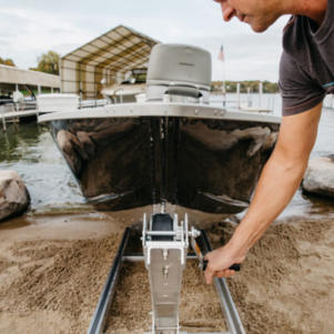 man pulling boat up ramp using hand crank